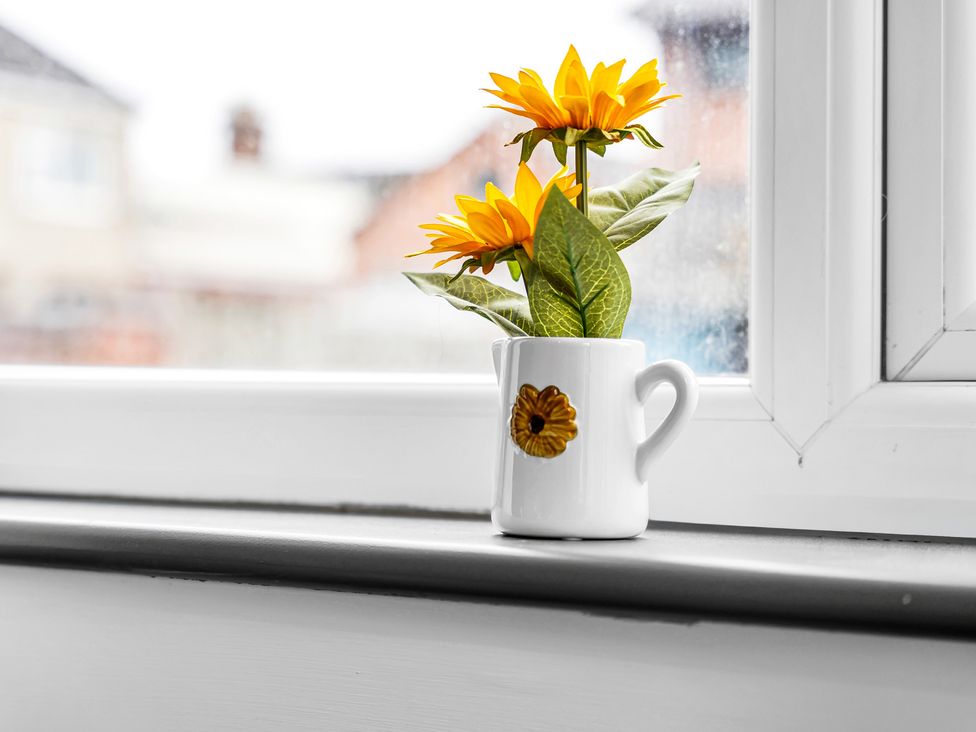 A mug with sunflowers on a windowsill at Victoria House, Stoke on Trent