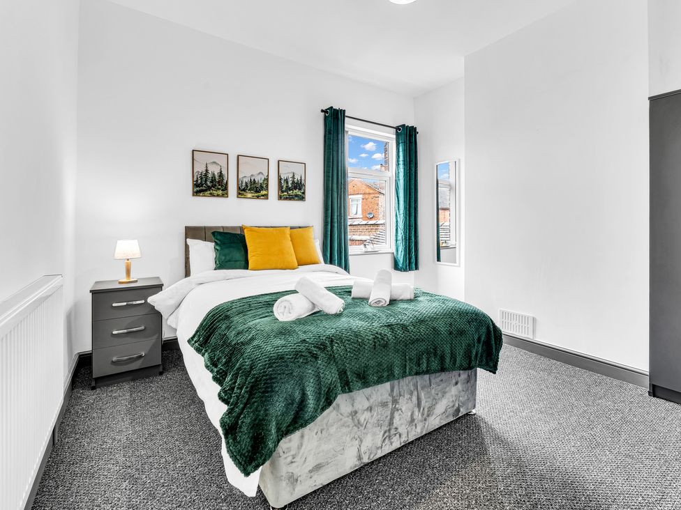 A bedroom with a bed and bedside table at Victoria House, Stoke on Trent
