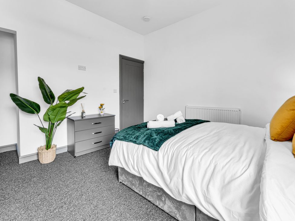A bedroom with a bed and chest of drawers at Victoria House, Stoke on Trent