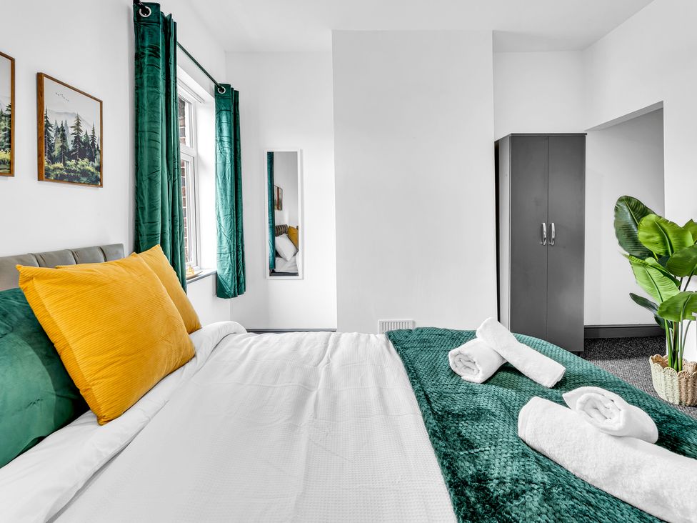 A bedroom with a bed and wardrobe at Victoria House, Stoke on Trent