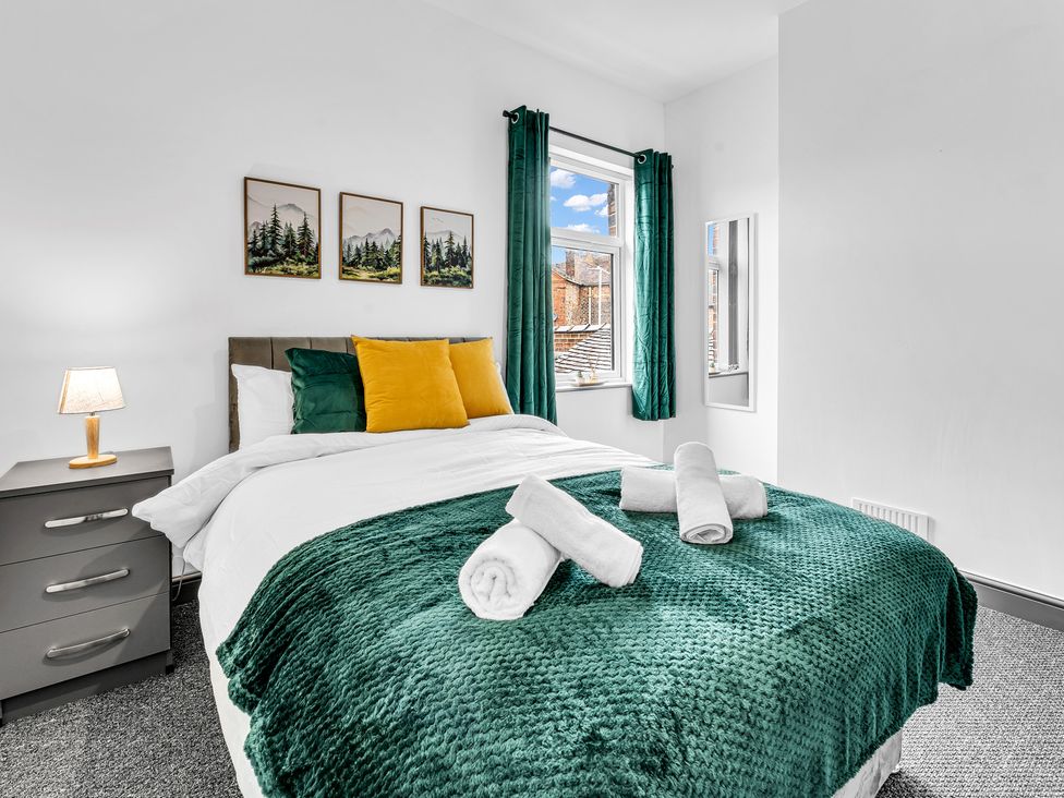 A bedroom with a bed and bedside table at Victoria House, Stoke on Trent