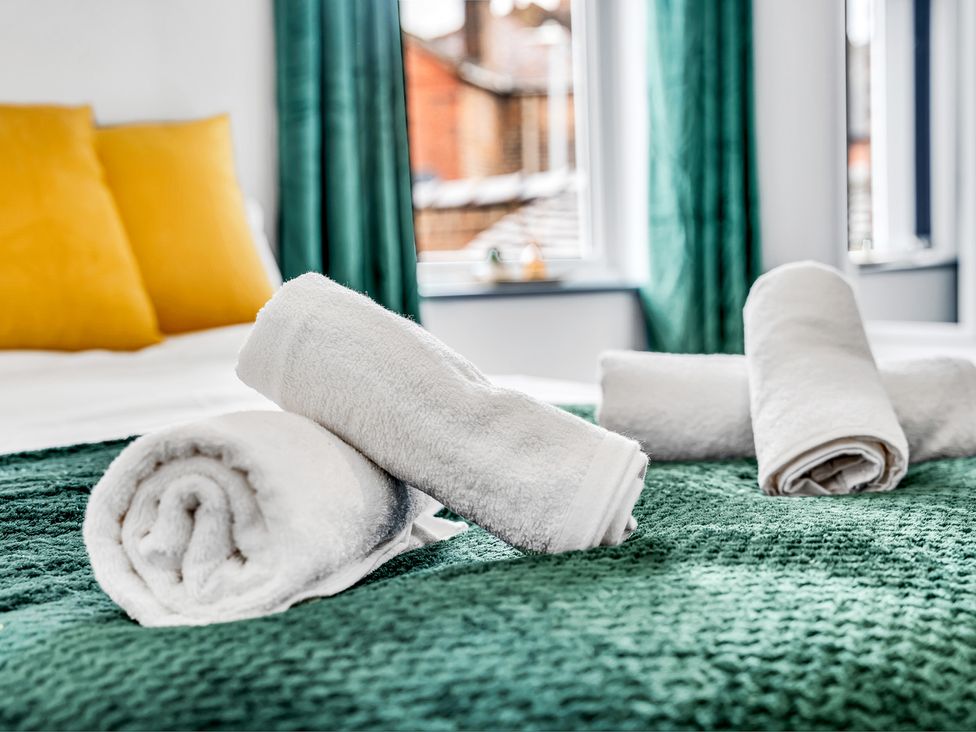 Towels and pillows on a bed at Victoria House, Stoke on Trent