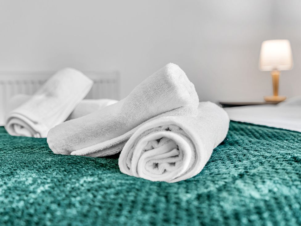 Towels on a bedspread in a bedroom at Victoria House, Stoke on Trent