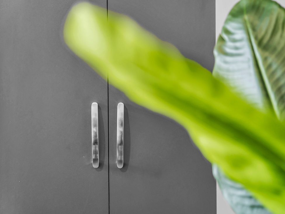 A cabinet with handles and plant leaves at Victoria House, Stoke on Trent