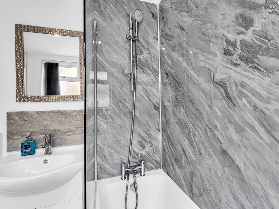 A bathroom with a bathtub and shower setup at Victoria House, Stoke on Trent