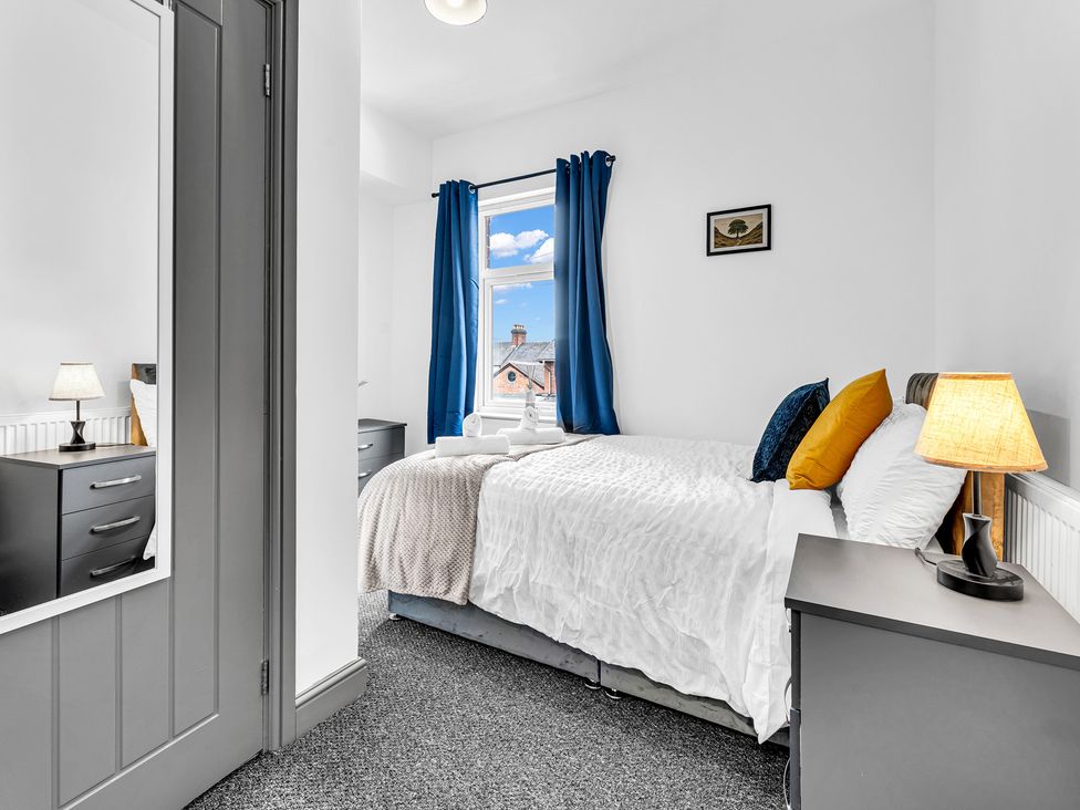 A bedroom with a bed and nightstand at Victoria House, Stoke on Trent