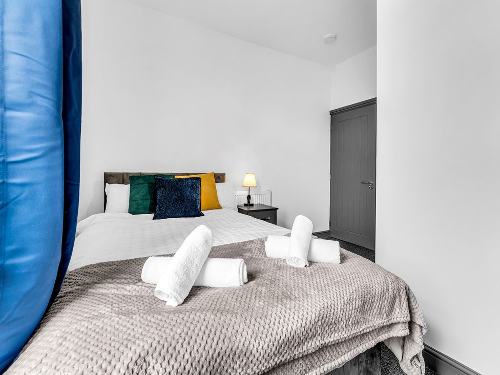 A bedroom with a bed and nightstand at Victoria House, Stoke on Trent