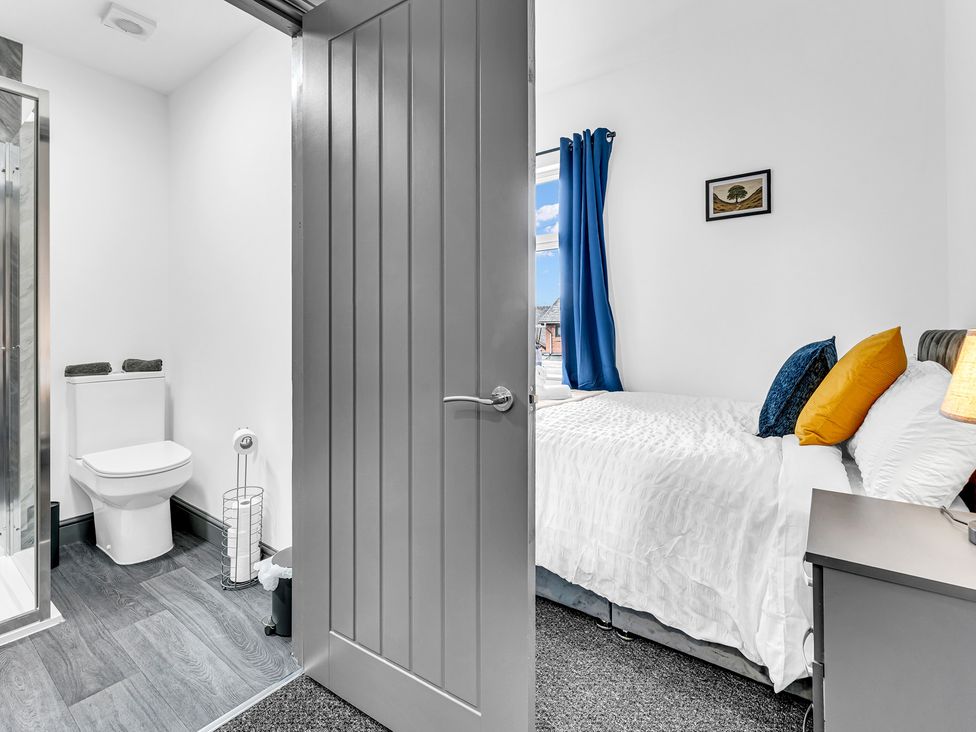 A bedroom with a bed and adjoining bathroom at Victoria House, Stoke on Trent