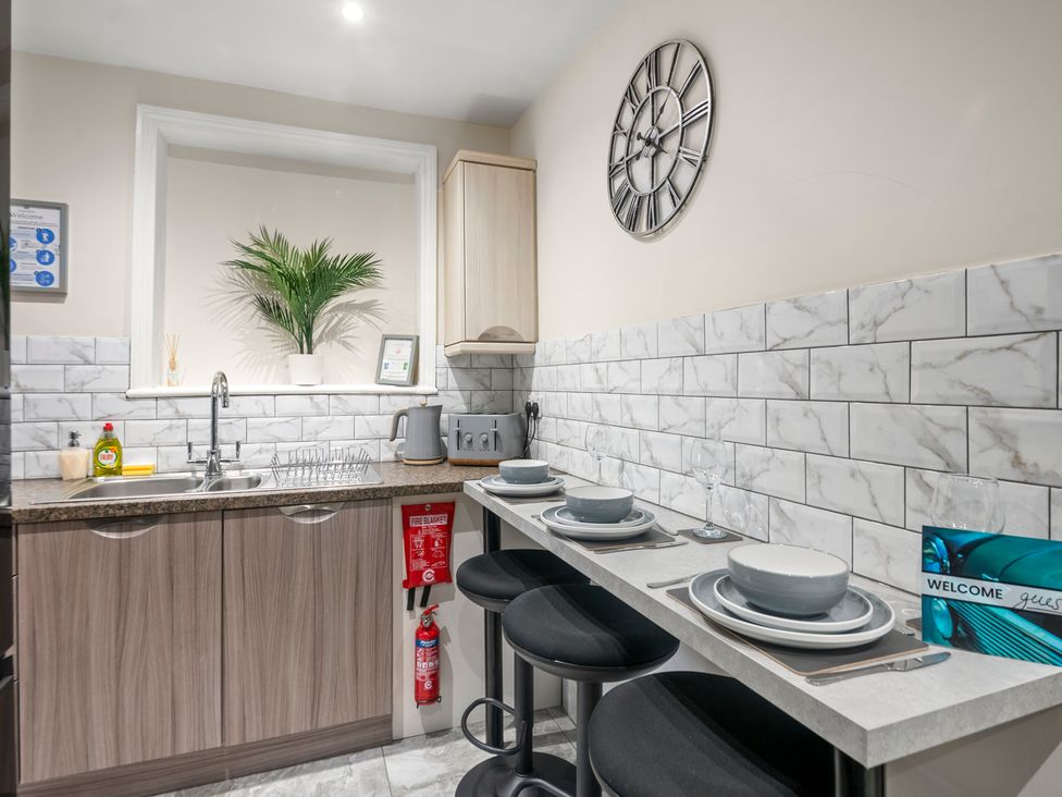 A kitchen with sink and counter seating at Oxford City Stay – Cooper House in Oxford