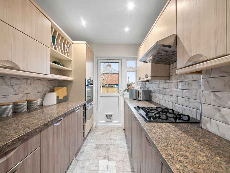 A kitchen with a gas stove and microwave at Oxford City Stay – Cooper House in Oxford