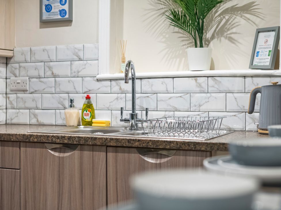 A kitchen with a sink, dish rack, and kettle at Oxford City Stay – Cooper House in Oxford