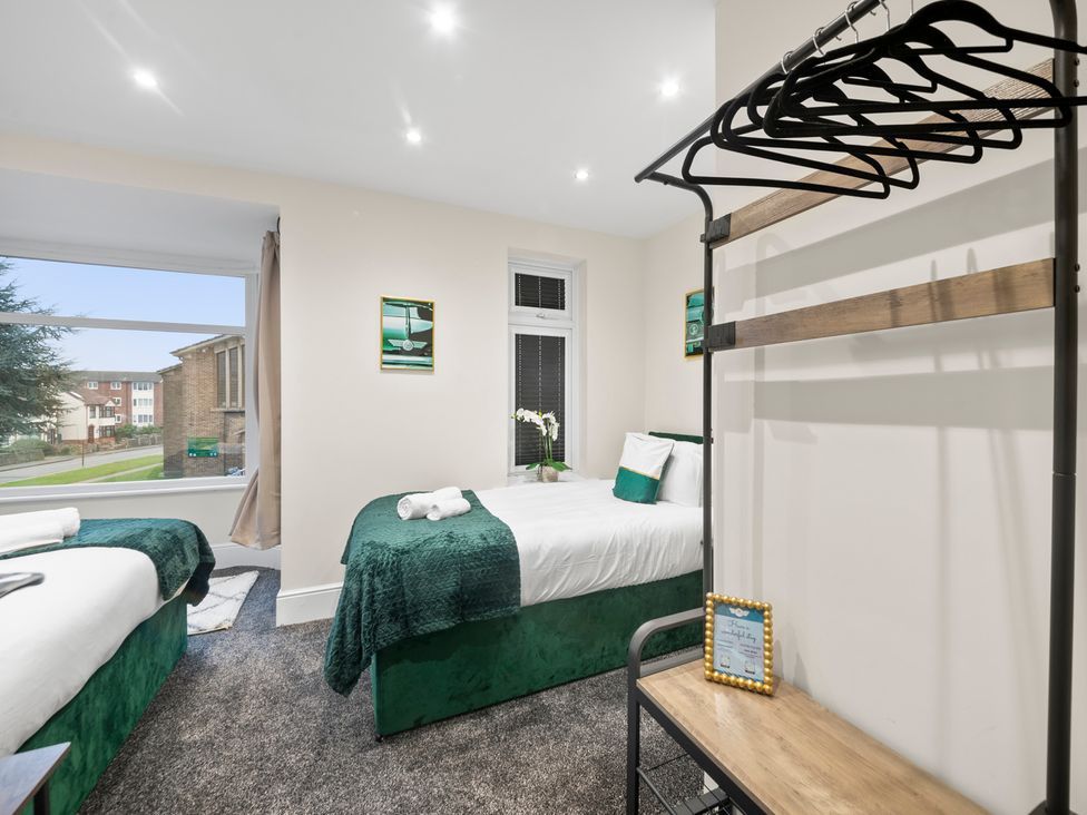 A bedroom with two beds, a window, and a hanging rack at Oxford City Stay – Cooper House, Oxford