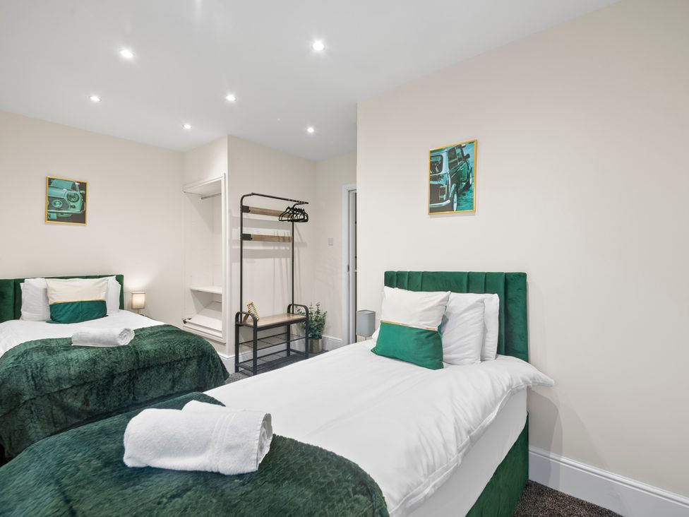 A bedroom with two beds and a wardrobe at Oxford City Stay – Cooper House in Oxford