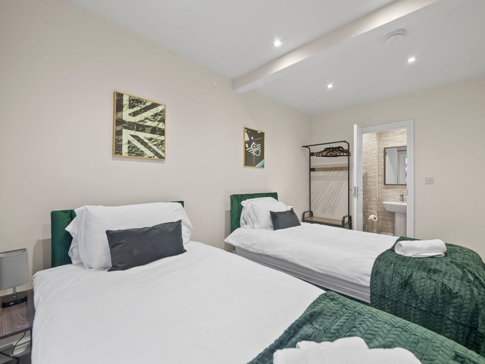 A bedroom with two beds and a wardrobe at Oxford City Stay – Cooper House, Oxford