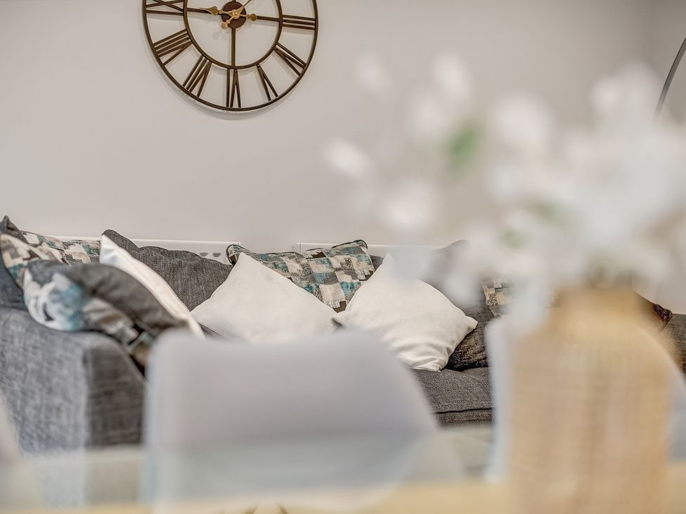 A living room with a sofa and wall clock at Oxford City Stay – Cowley House, Oxford