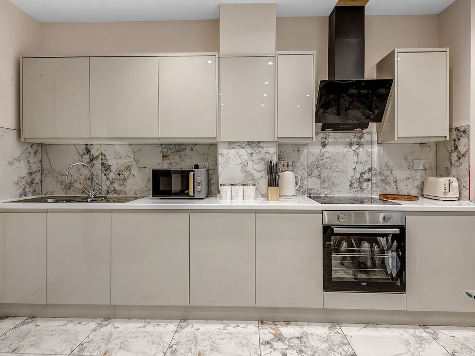A kitchen with cabinets and appliances at Oxford City Stay – Cowley House in Oxford