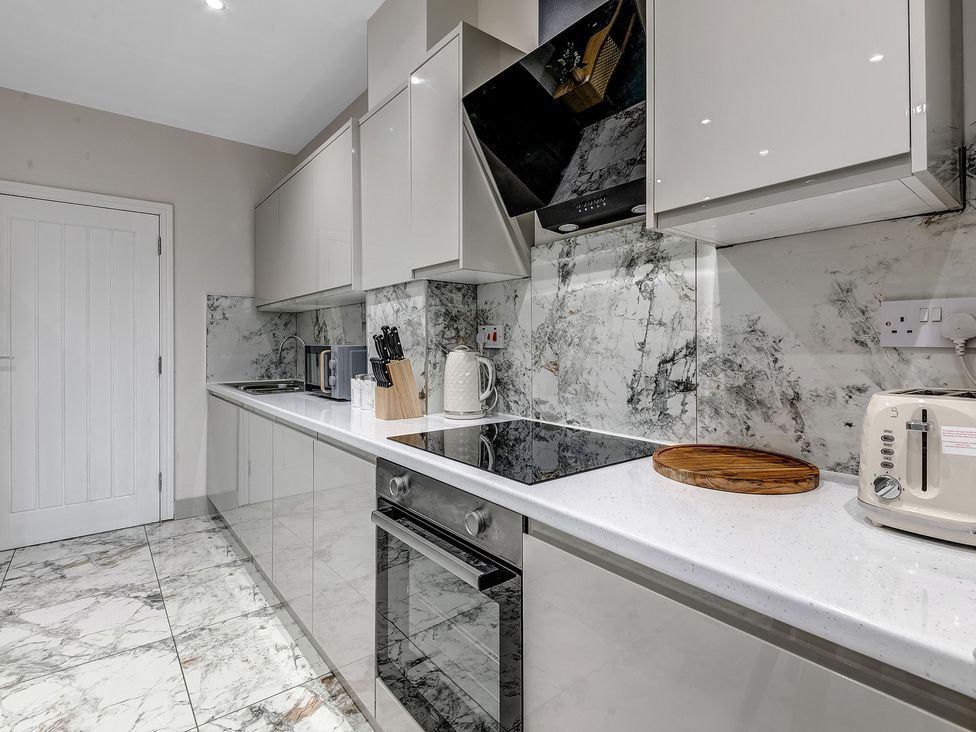 A kitchen with cabinets, stove and utensils at Oxford City Stay – Cowley House in Oxford