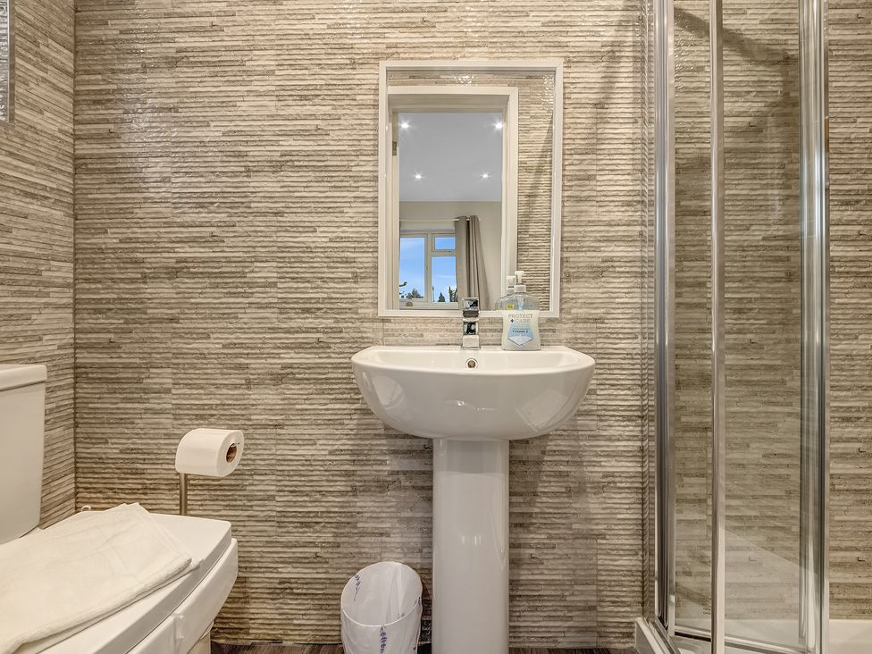 A bathroom with a sink, toilet, shower, and mirror at Oxford City Stay – Cowley House, Oxford