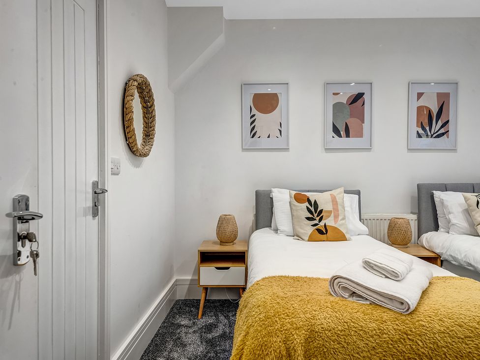 A bedroom with two beds and artwork on the wall at Oxford City Stay – Cowley House in Oxford