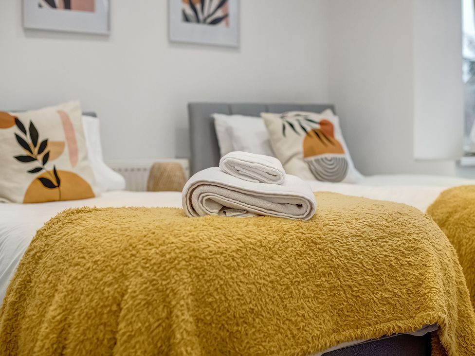 A bedroom with a bed, towels, cushions and a blanket at Oxford City Stay – Cowley House in Oxford