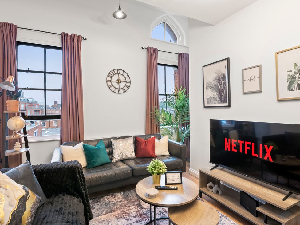A living room with a sofa and television at The Hallmark Birmingham Flat Birmingham