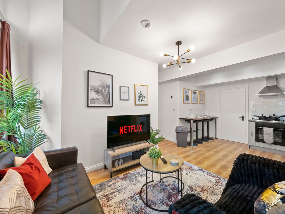 A living room with a television and sofa at The Hallmark Birmingham Flat in Birmingham