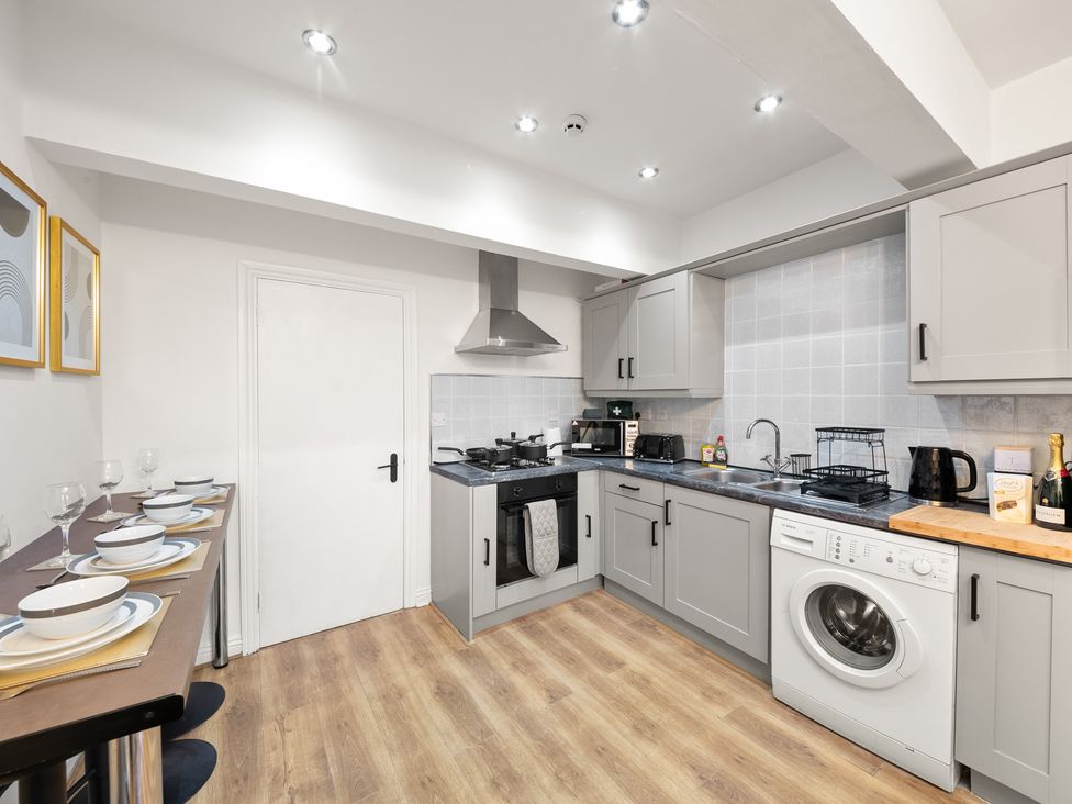 A kitchen with a stove, microwave, and washing machine at The Hallmark Birmingham Flat Birmingham