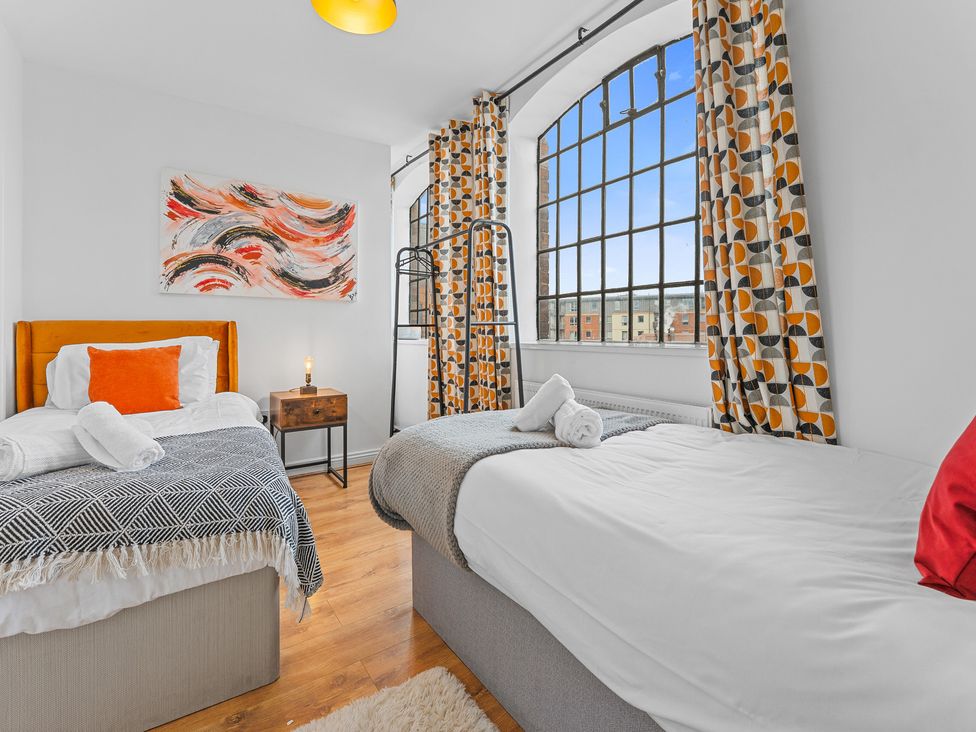 A bedroom with two beds and a bedside table at The Hallmark Birmingham Flat Birmingham