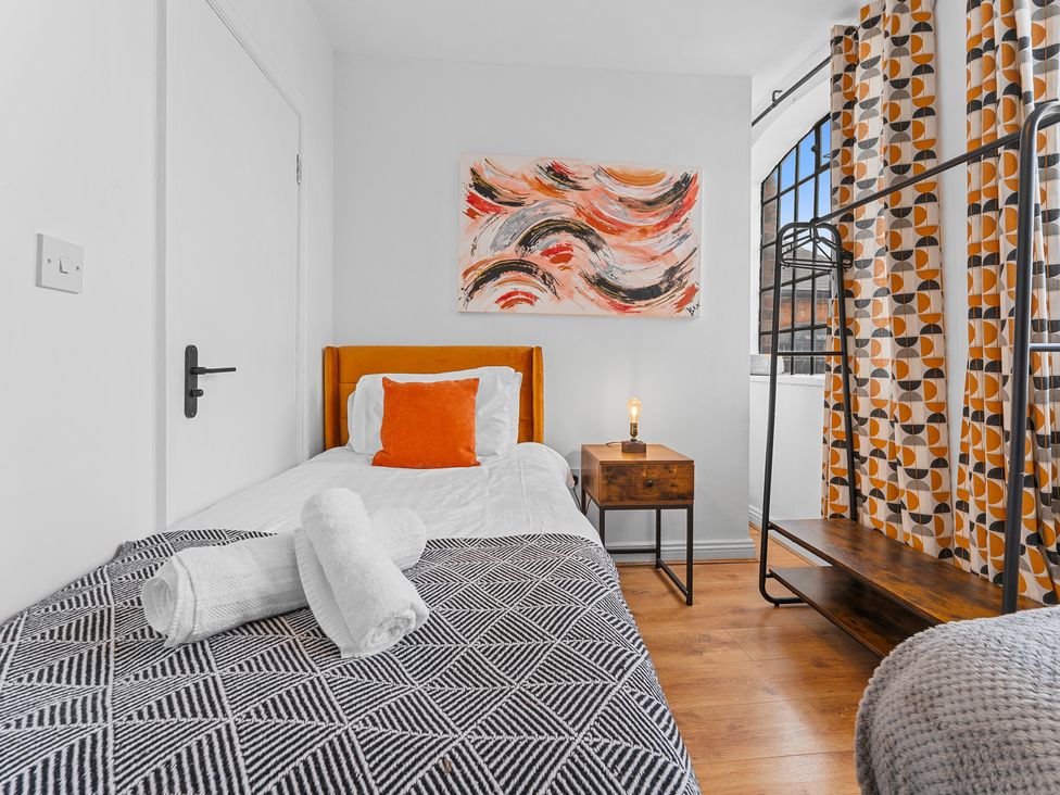 A bedroom with a bed and nightstand at The Hallmark Birmingham Flat Birmingham