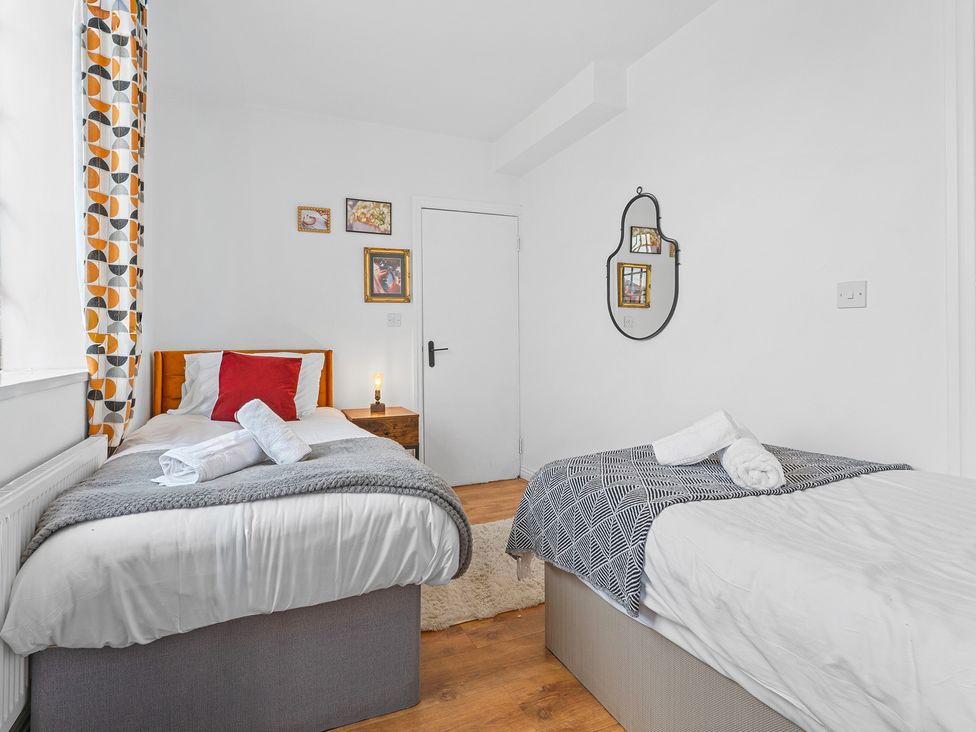 A bedroom with two beds and a mirror at The Hallmark Birmingham Flat Birmingham
