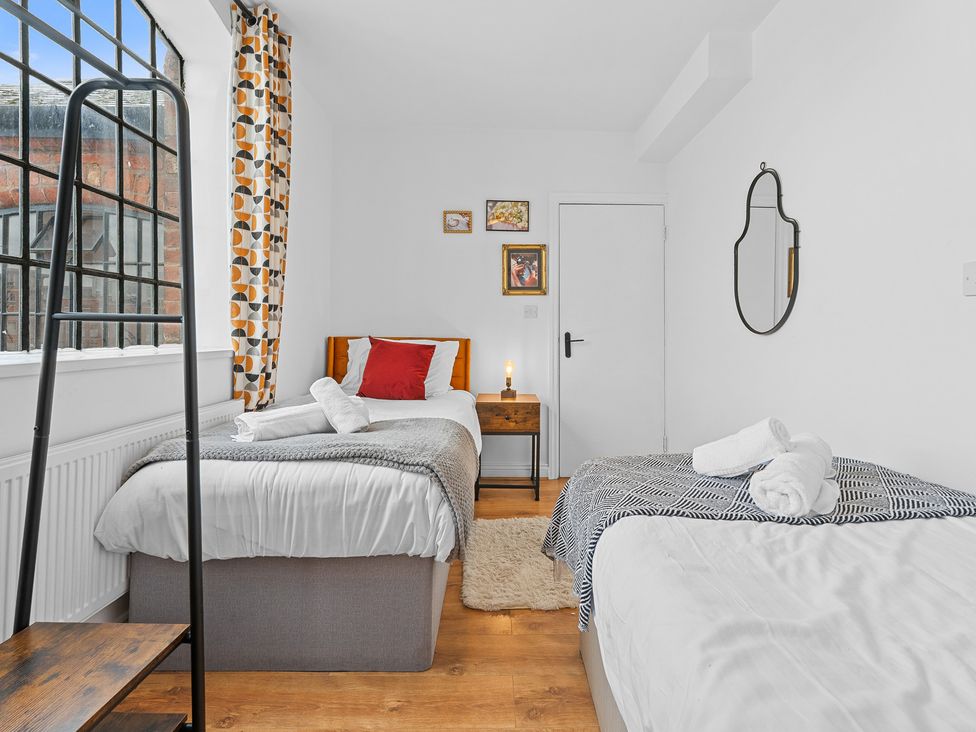A bedroom with two beds and a nightstand at The Hallmark Birmingham Flat Birmingham