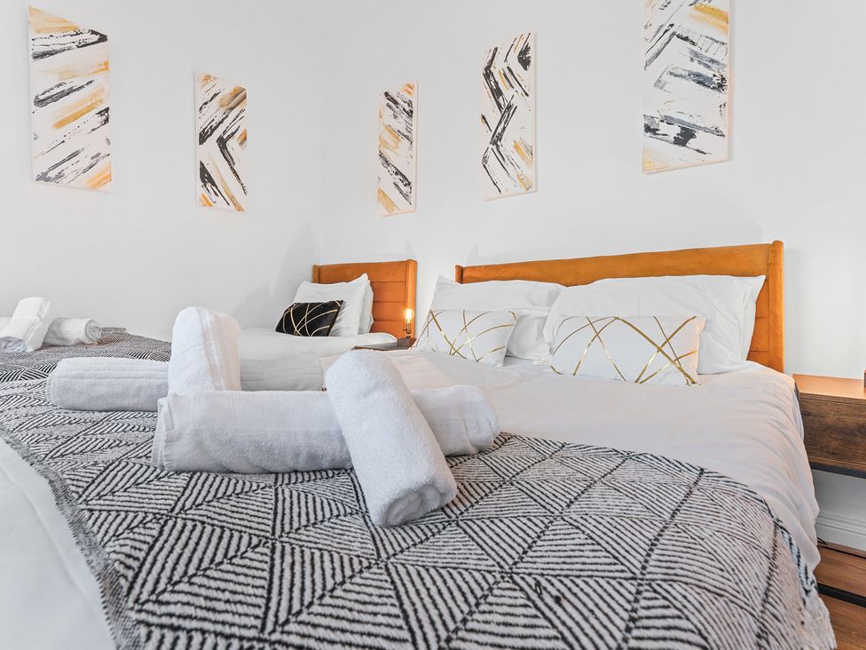 A bedroom with beds and wall art at The Hallmark Birmingham Flat in Birmingham