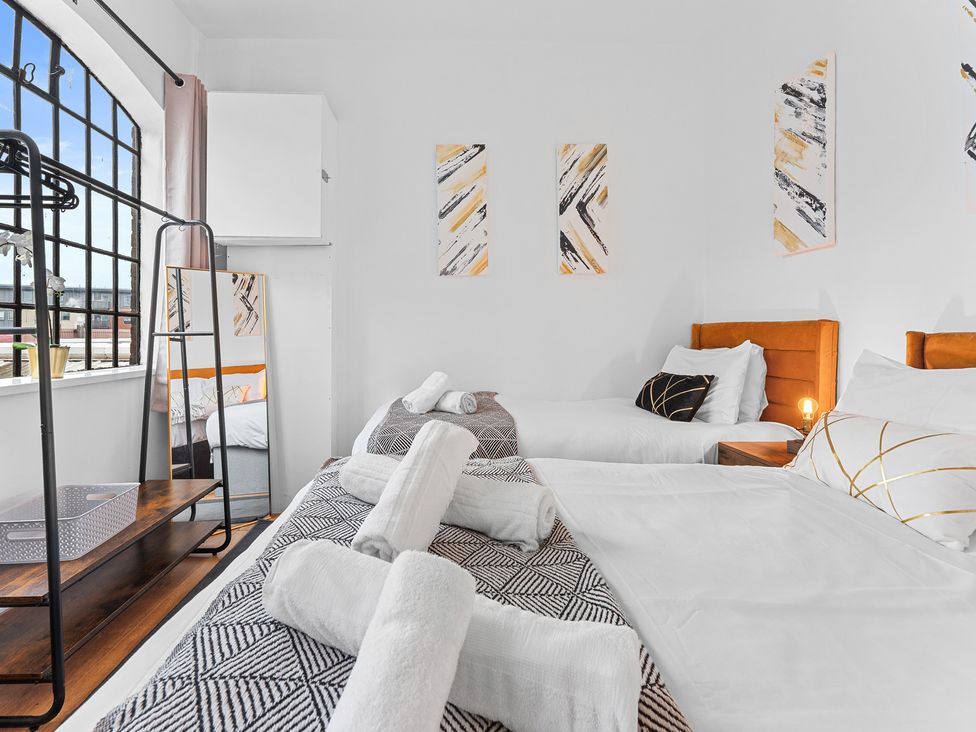 A bedroom with two beds and a nightstand at The Hallmark Birmingham Flat Birmingham