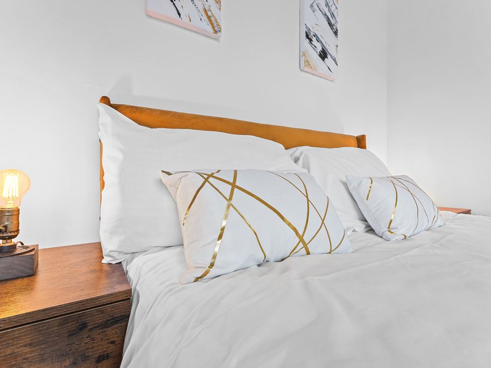 A bed with pillows and a lamp in the bedroom at The Hallmark Birmingham Flat Birmingham