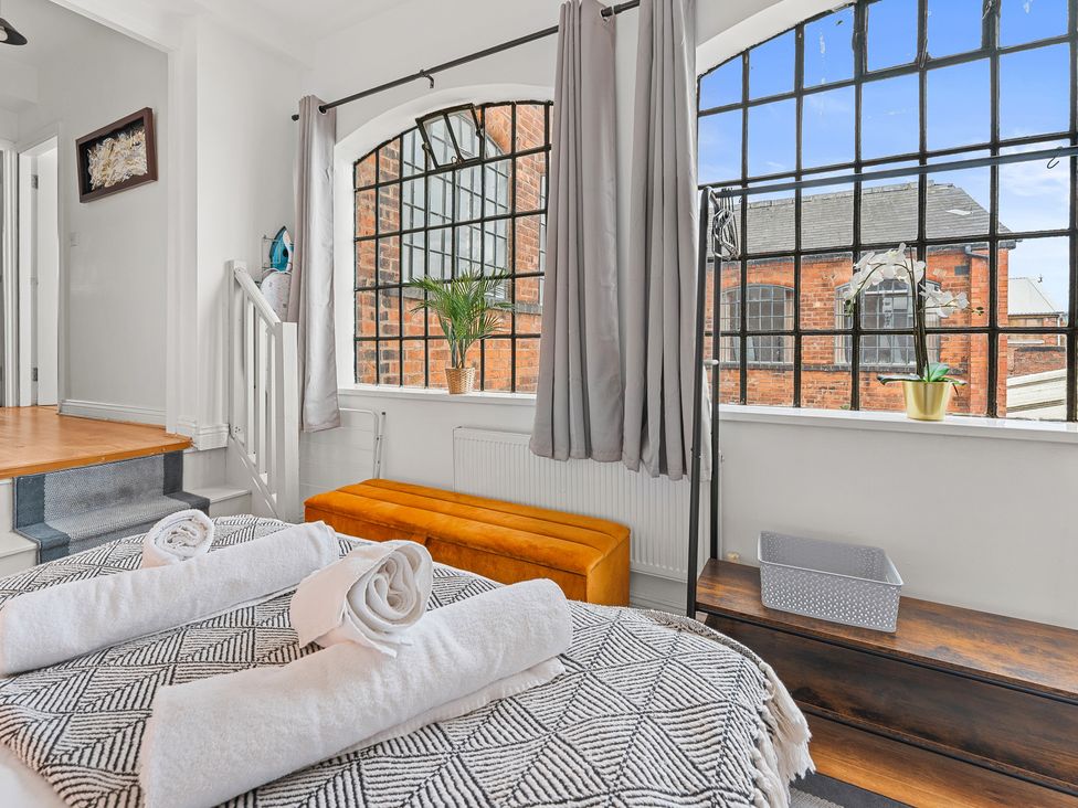 A bedroom with a bed and large windows at The Hallmark Birmingham Flat Birmingham