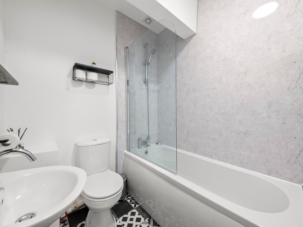 A bathroom with a bathtub, toilet, and sink at The Hallmark Birmingham Flat Birmingham