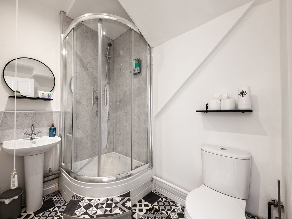 A bathroom with a shower, toilet, and sink at The Hallmark Birmingham Flat