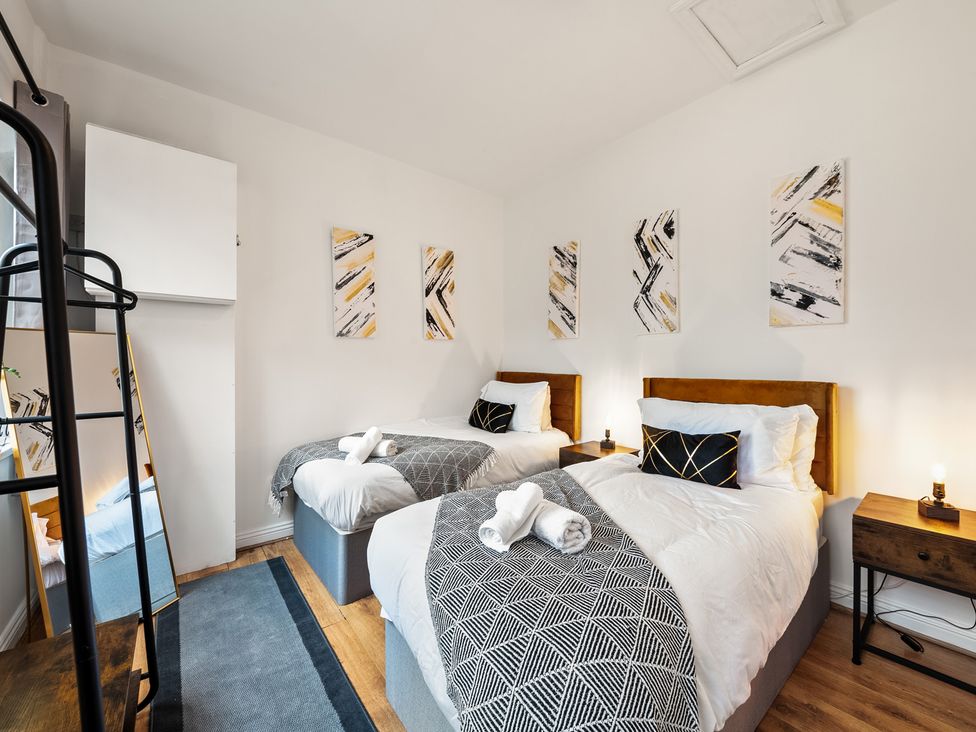 A bedroom with two beds and a mirror at The Hallmark Birmingham Flat Birmingham