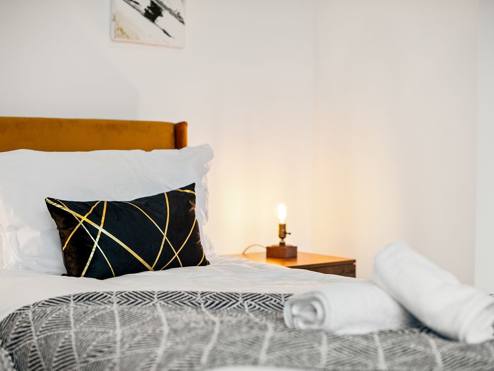 A bedroom with a bed and a nightstand at The Hallmark Birmingham Flat Birmingham