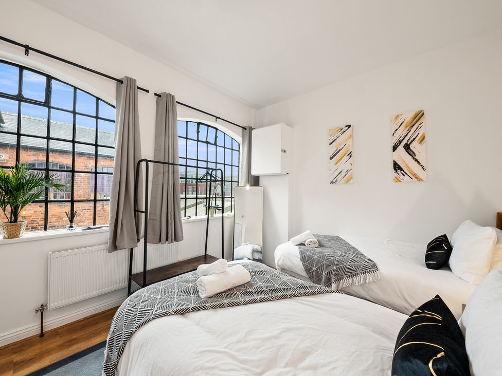 A bedroom with two beds and large windows at The Hallmark Birmingham Flat Birmingham
