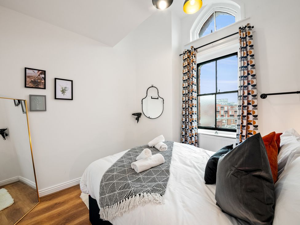 A bedroom with a bed and mirror at The Hallmark Birmingham Flat Birmingham