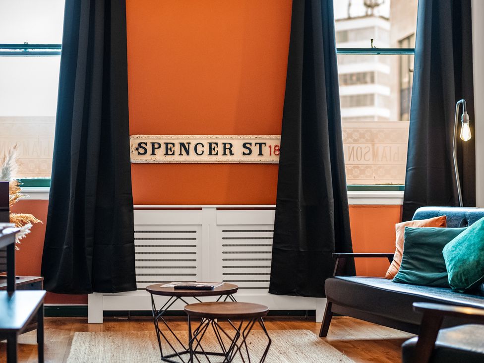 A living room with a sofa and a decorative sign at The Jewel Box Birmingham City Apartment Birmingham