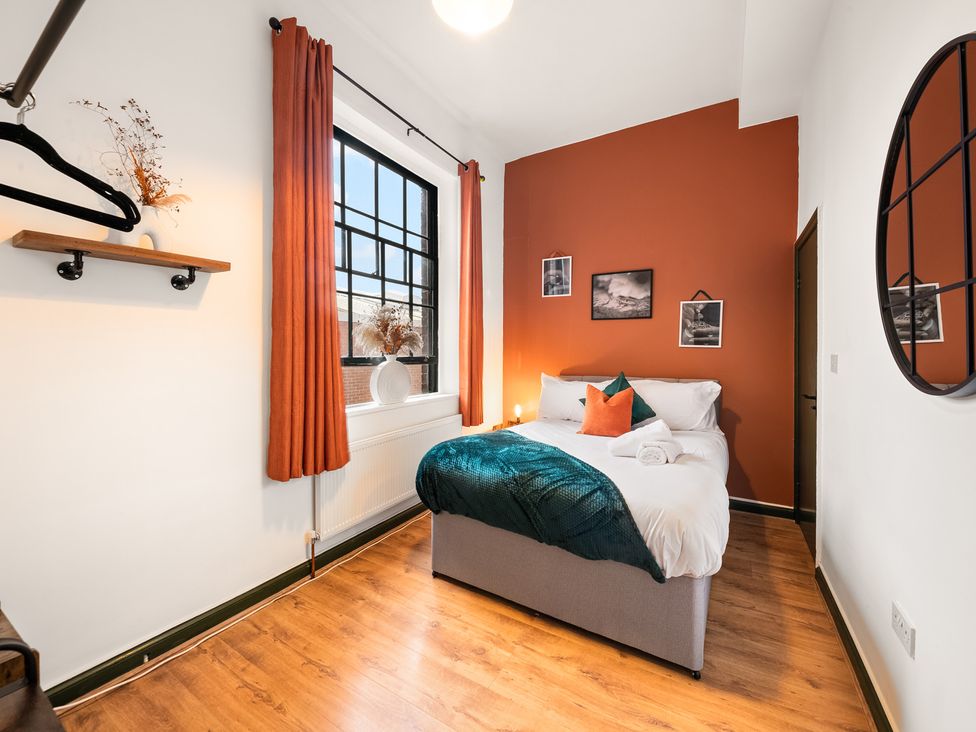 A bedroom with a bed, shelf, and window at The Jewel Box Birmingham City Apartment Birmingham