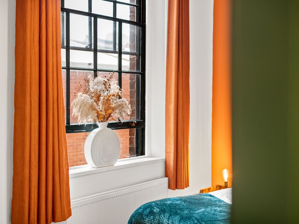 A bedroom with a window and vase of dried flowers at The Jewel Box Birmingham City Apartment Birmingham