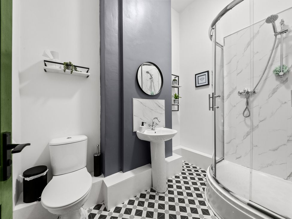 A bathroom with a toilet, sink, shower, and mirror at The Jewel Box Birmingham City Apartment Birmingham