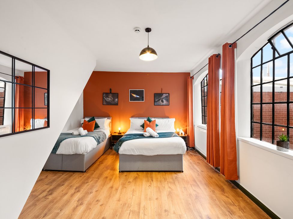 A bedroom with two beds and large windows at The Jewel Box Birmingham City Apartment Birmingham