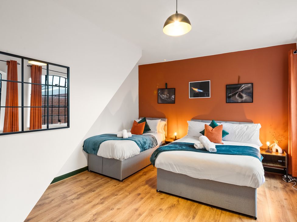 A bedroom with two beds and artwork on the walls at The Jewel Box Birmingham City Apartment Birmingham