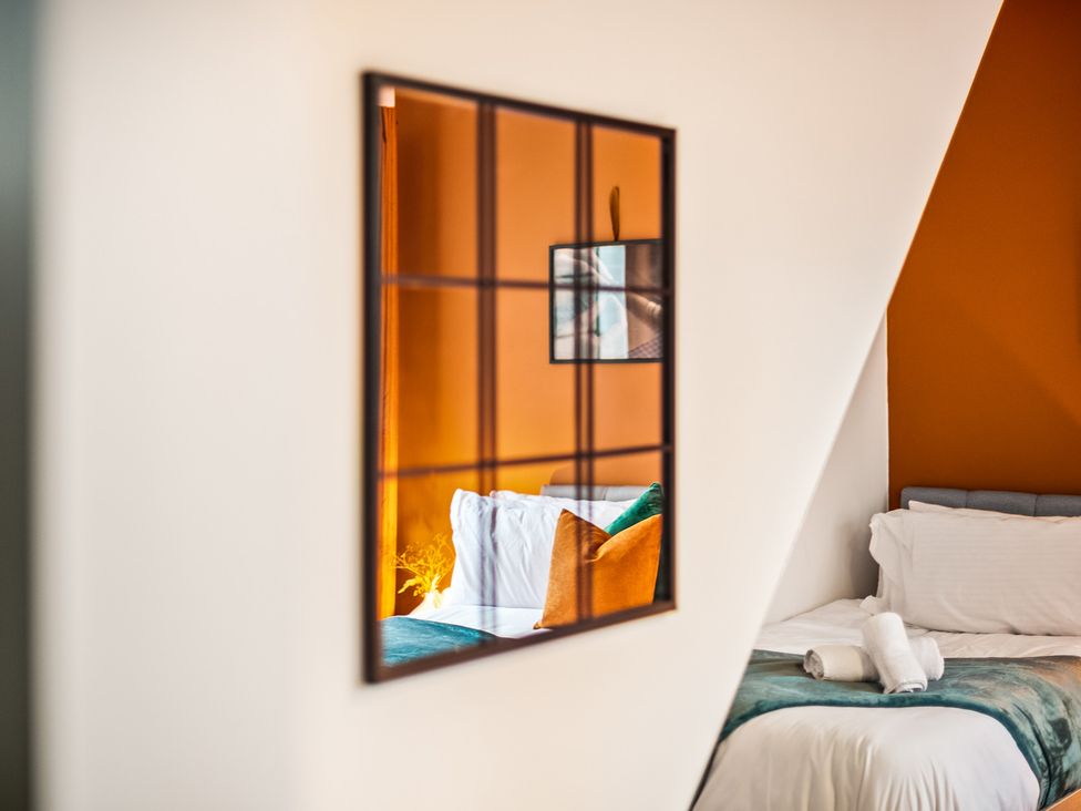A bedroom with a mirror and bed at The Jewel Box Birmingham City Apartment Birmingham