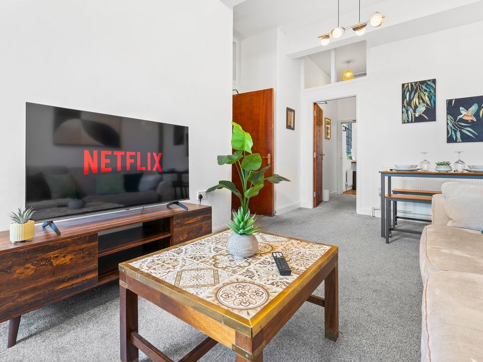 A living room with a TV and coffee table at The Gilder Birmingham City Apartment in Birmingham