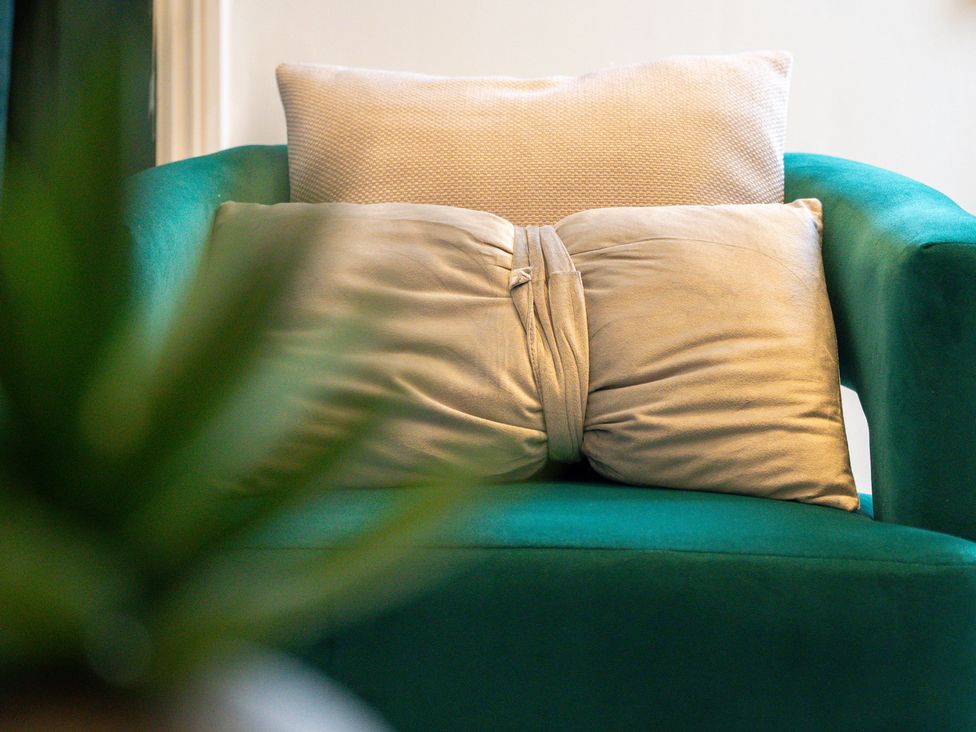 A living room with cushions on an armchair at The Gilder Birmingham City Apartment in Birmingham